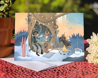 May include: A greeting card illustration of a girl and animals gathered around a campfire in a snowy forest. The girl is pouring hot chocolate from a thermos into a mug. The animals include a fox, a squirrel, and two porcupines. The scene is set at dusk with a warm orange sky and a string of lights hanging from a tree.