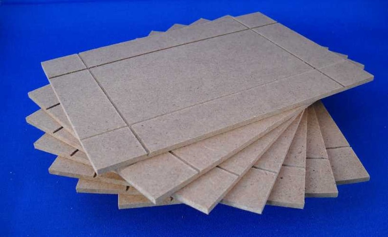 May include: A stack of six beige, rectangular pieces of wood with a grid pattern. The wood is unfinished and has a rough texture.