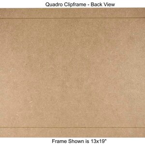 May include: Back view of a brown wood picture frame with silver metal clips. The frame is 13 inches by 19 inches. "Quadro Clipframe - Back View" and "Frame Shown is 13x19" are printed on the frame.