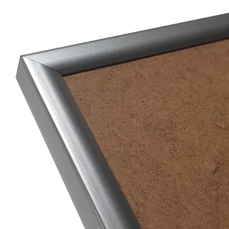 May include: A silver picture frame with a brown cardboard backing.