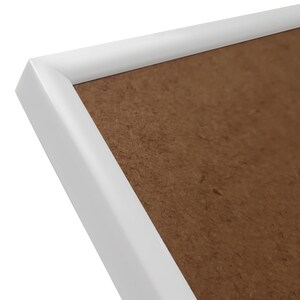 May include: White picture frame with a brown cardboard backing.