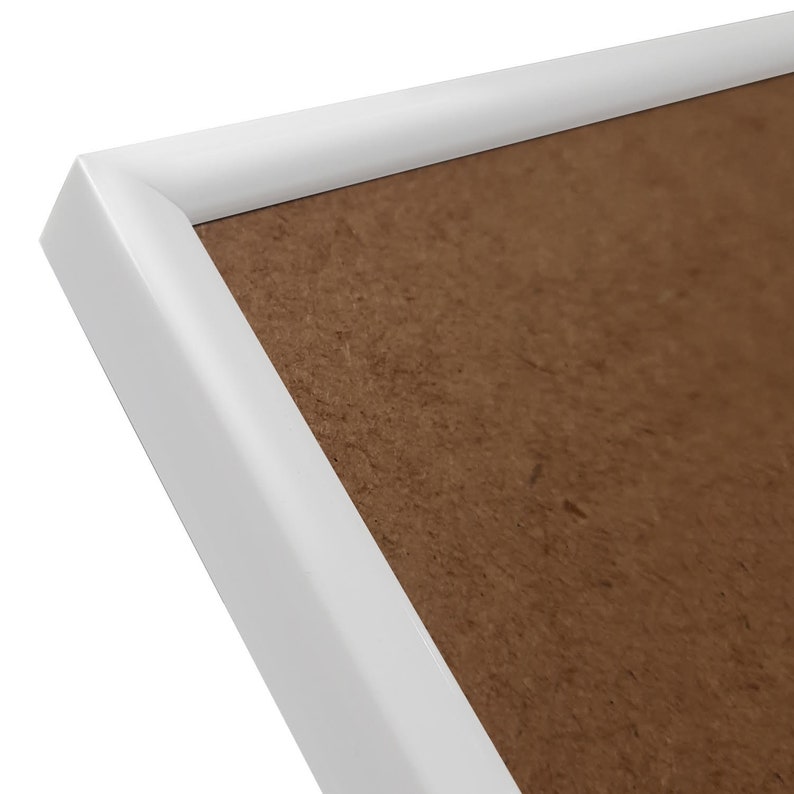 May include: White picture frame with a brown cardboard backing.