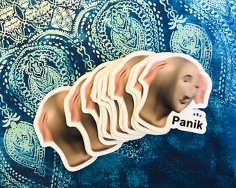 May include: A stack of stickers featuring a cartoon face with hands covering the eyes and the word "Panik" in black text.