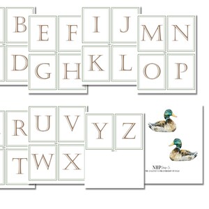 Pu&ograve; includere: Un set di flashcard dell'alfabeto con lettere marroni su sfondo bianco con bordo verde. Le lettere sono in un font tradizionale. Ci sono due immagini di un'anatra selvatica su sfondo bianco con il testo "NHP Designs" e "L'arte di creare ricordi che durano tutta la vita".