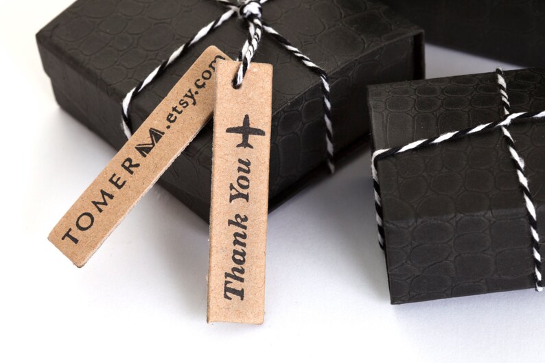 May include: Two black gift boxes with white string and brown gift tags. One tag says "TOMERM.etsy.com" and the other says "Thank You" with a small airplane icon.