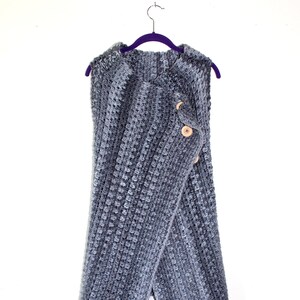 May include: A gray hooded crocheted vest with two wooden buttons.
