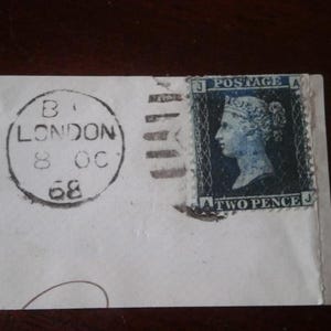 Un sello azul de dos peniques JA en pieza Londres 1868