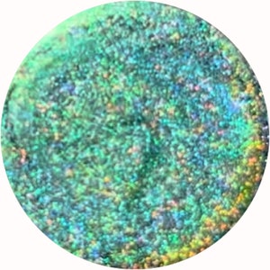 Op de afbeelding: Een close-up van een cirkelvormig, iriserend oppervlak met een getextureerd, gespikkeld uiterlijk. Het kleurenpalet omvat tinten groen, blauw en hints van geel en oranje, waardoor een glinsterend effect ontstaat. De algehele esthetiek suggereert een natuurlijk of abstract ontwerp.