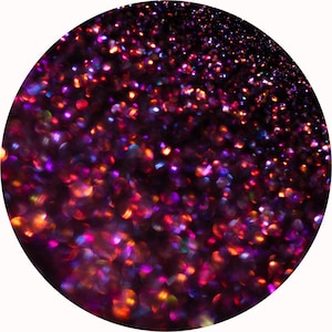 Puede incluir: Imagen circular llena de una textura brillante y con purpurina. La purpurina es una mezcla de tonos morados oscuros, rojos y naranjas, creando un efecto visual vibrante y dinámico. Las partículas de purpurina están densamente empaquetadas.