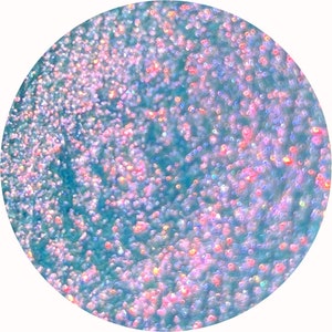 May include: A close-up of a blue glitter with iridescent pink and blue sparkles.