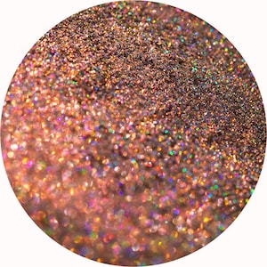 May include: Close-up of a circular area filled with shimmering glitter. The glitter transitions from a light, warm rose gold at the bottom to a darker, bronze-toned shade at the top. Iridescent flecks create a rainbow effect.