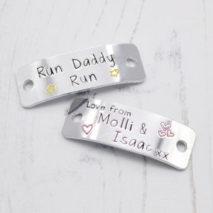 May include: Two silver metal tags with personalized messages. The top tag reads "Run Daddy Run" with a yellow star on each side. The bottom tag reads "Love from Molli & Isaac xx" with a red heart on the left and three red hearts on the right.