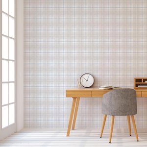 May include: A light wood desk with a gray upholstered chair. The desk has two drawers and a clock on the surface. The wall behind the desk is covered in a light gray and blue plaid wallpaper.