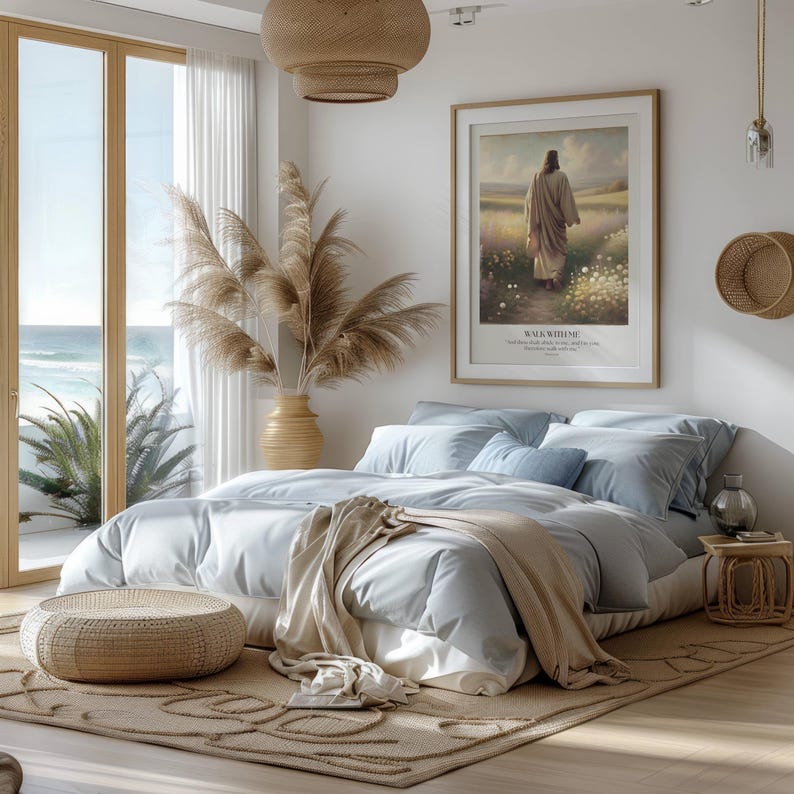 Puede incluir: Un dormitorio sereno con una cama grande cubierta con ropa de cama y almohadas de color azul claro. Una obra de arte enmarcada cuelga sobre la cama, y una alfombra y un otom&aacute;n tejidos est&aacute;n en el suelo. Una gran ventana ofrece una vista del oc&eacute;ano.