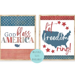 Puede incluir: Dos impresiones enmarcadas con temas patri&oacute;ticos. La primera impresi&oacute;n presenta un dise&ntilde;o de bandera estadounidense rojo, blanco y azul con el texto "God Bless America". La segunda impresi&oacute;n presenta un contorno azul de los Estados Unidos con estrellas rojas y el texto "Let Freedom Ring!"
