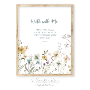May include: A framed art print with a light wood frame. The print features the text "Walk with Me" in green script, along with a quote from Moses. Watercolor flowers in yellow, blue, and purple adorn the bottom. The Willarston Way logo is at the bottom.