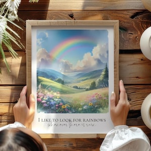 May include: A framed print featuring a vibrant rainbow arching over a picturesque landscape of rolling green hills, wildflowers, and a blue sky. The print includes the text: "I like to look for rainbows whenever there is rain."