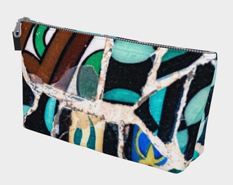 Puede incluir: Una bolsa de maquillaje colorida con un patrón de mosaico que presenta tonos de azul, verde, marrón y blanco.
