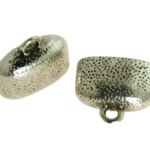 May include: Two silver-toned metal caps with a textured surface and a small loop on top. The caps are oval-shaped and have a hammered finish.