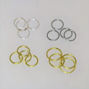 May include: Three sets of jump rings in silver, gold, and black metal. Each set contains three jump rings.