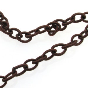 May include: Brown elastic chain with oval links. The chain is made of a soft, flexible material and is perfect for adding a touch of style to any project.
