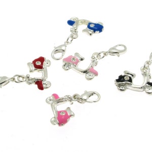 May include: Five silver charm pendants shaped like scooters with different colored paint jobs. The scooters have a silver clasp on the back. The colors are red, pink, blue, black, and pink.
