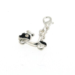 May include: Silver charm in the shape of a black scooter with a silver clasp.