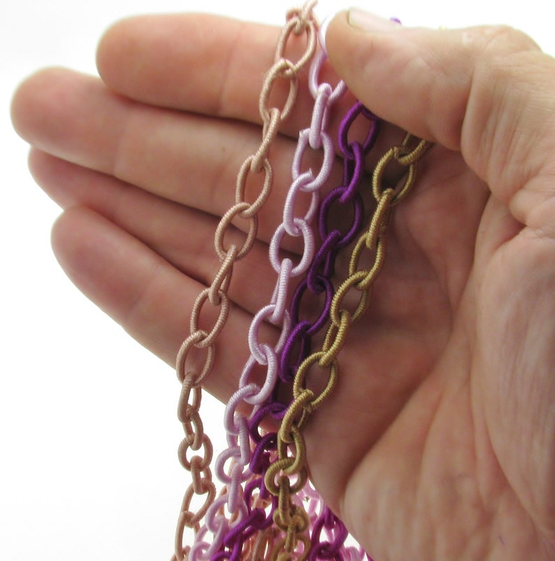 May include: Four strands of elastic chain in different colors: gold, pink, light pink, and purple.