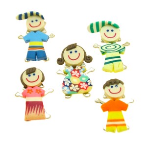 May include: Set of six colourful, smiling, cartoon people figurines. Each figurine has a different outfit and hairstyle. The figurines are made of clay and have a whimsical, handmade look.