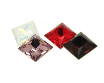 May include: Four square-shaped rhinestones in different colours: clear, pink, red, and black.