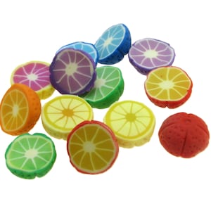 Peut inclure: Assortiment de tranches de fruits colorées en pâte polymère. Les tranches comprennent du citron vert, du citron, de l'orange, du pamplemousse et une orange rouge entière.