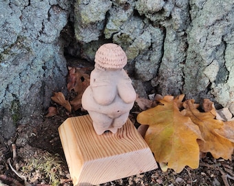 handmade ceramik sculpture Venus of Willendorf  on the wooden stand