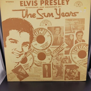 May include: A yellow and brown record album cover featuring a photo of Elvis Presley with the text "Elvis Presley Interviews and Memories of: The Sun Years". The cover includes several smaller photos of Elvis Presley and the text "Sun 1001".