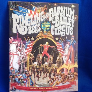 May include: A vintage program for the Ringling Bros. and Barnum & Bailey Circus, featuring a colorful illustration of a horse-drawn chariot with tigers and a performer in the air. The program is titled "The Greatest Show on Earth" and includes the text "Spectacular Bicentennial Edition".