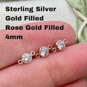 May include: Three 4mm round connector charms with clear cubic zirconia stones. The charms are shown in sterling silver, gold filled, and rose gold filled.