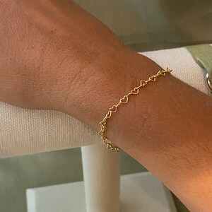 May include: A gold heart-shaped chain bracelet. The bracelet is delicate and dainty, and would make a great gift for a loved one.