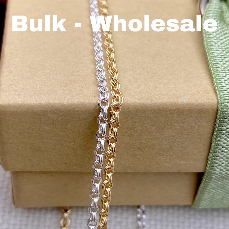 May include: Two strands of chain, one silver and one gold, are displayed on a brown box with the text "Bulk - Wholesale" printed on the top.