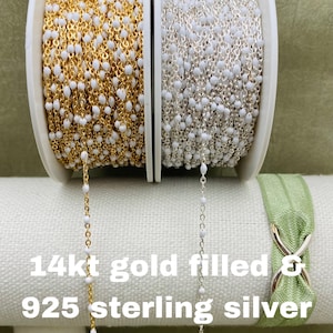 May include: Two spools of chain, one gold filled and one sterling silver. Both chains feature white beads.