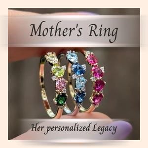 May include: Three gold rings with colorful oval gemstones, including green, pink, blue, and red, are displayed. The rings are labeled "Mother's Ring" and "Her personalized Legacy."