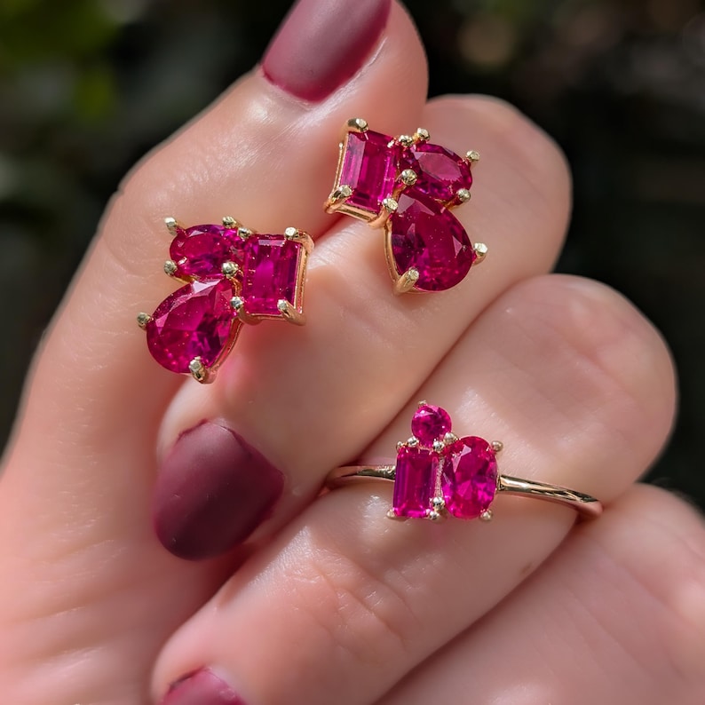 Peut inclure: Un ensemble de bijoux en or, compos&eacute; d'une bague et de boucles d'oreilles assorties, serti de pierres pr&eacute;cieuses roses vives. La bague pr&eacute;sente une pierre ovale et deux pierres rectangulaires. Les boucles d'oreilles ont un groupe de pierres en forme de poire et rectangulaires.