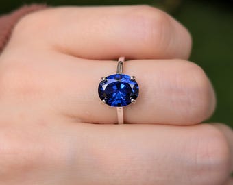 Grote ovale saffierring, 6 x 8 mm of 8 x 10 mm, diepblauwe synthetische saffier, in zilver, geelgoud of witgoud.
