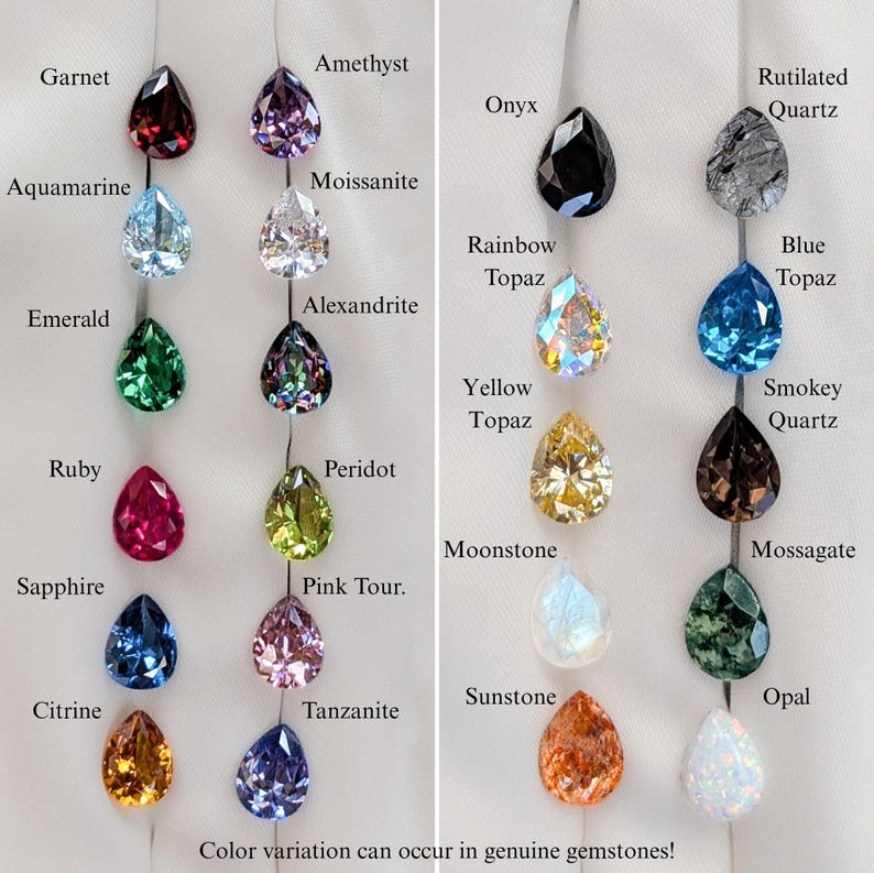 May include: An assortment of teardrop-shaped gemstones in a range of colours, such as garnet, amethyst, aquamarine, emerald, ruby, sapphire, citrine, onyx, rainbow topaz, blue topaz, and others. Each gem is labelled. Text at the bottom: "Color variation can occur in genuine gemstones!"