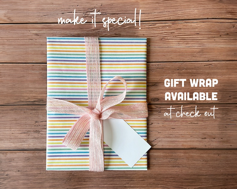 May include: A colorful striped gift wrap with a pink ribbon and a blank gift tag. The text "GIFT WRAP AVAILABLE at check out" is visible in the image.