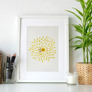 daisy art in a white frame leaning on office desk