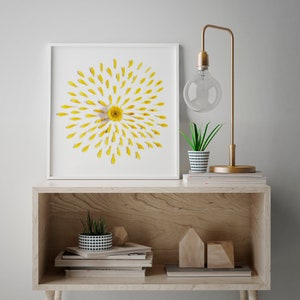 daisy art in a frame leaning on a wooden furniture