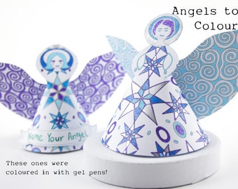Può includere: Due ornamenti di angeli di carta con ali e un motivo a stella. Gli angeli sono bianchi con accenti blu e viola. Il testo "Name Your Angel" è in basso su un angelo. Il testo "Angels to Colour" è in alto nell'immagine.