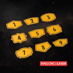 May include: Nine yellow wooden number signs, each with a black border and a different number from one to nine. The signs have various shapes, including rectangles, ovals, and a decorative shape. The text "SVG | CNC | LASER" is in the bottom right corner.
