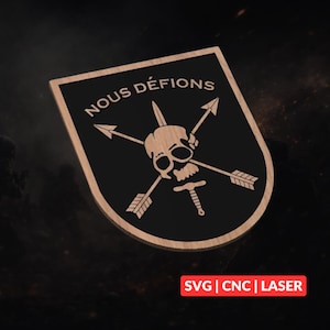 May include: Wooden plaque with a black shield design. The shield features a skull with crossed arrows and the text "NOUS DÉFIONS". The bottom right corner of the plaque has the text "SVG | CNC | LASER".
