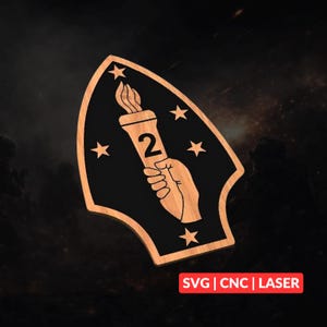 Peut inclure: Une plaque en bois en forme de bouclier avec une incrustation noire et une bordure en bois clair. Le motif représente une main tenant une torche enflammée avec le chiffre 2 au centre, entouré de cinq étoiles. Le texte indique SVG | CNC | LASER.