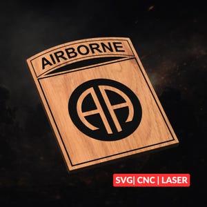 Könnte beinhalten: Holztafel mit dem Wort "AIRBORNE" oben und einem schwarzen Kreis mit "AA" darin. Die Tafel ist rechteckig mit gewölbter Oberseite. Der Text "SVG | CNC | LASER" befindet sich unten.
